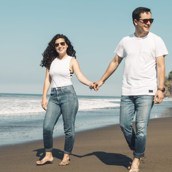 couple-walking-barefoot-sandy-beach